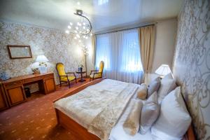 a bedroom with a large bed and a desk and chairs at Hotel Imperium in Piekary Śląskie