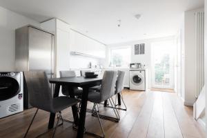 een keuken met een tafel en stoelen in een kamer bij The Jericho Escape - Comfortable & Modern 4BDR House in Oxford