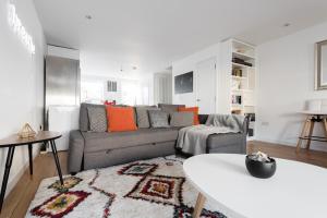 - un salon avec un canapé gris et des oreillers orange dans l'établissement The Jericho Escape - Comfortable & Modern 4BDR House, à Oxford