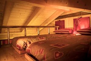 a bedroom with two beds in a log cabin at Il Nido del Casalot in Frassino