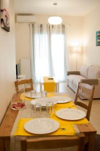 uma sala de estar com uma mesa com pratos em Cozy Bright Apartment em Atenas