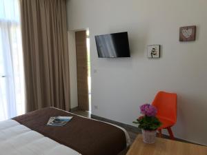 パトリモニオにあるA Funtana seccaのベッド1台、壁掛けテレビが備わるホテルルームです。