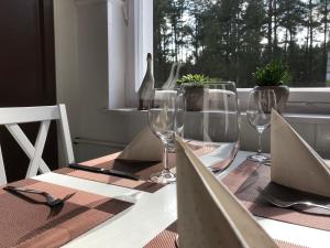 a table with wine glasses and a swan on a window at Villa Seeidyll in Prieros