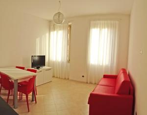 カンピョーネ・デル・ガルダにあるCampione Ora apartments by Gardadomusmeaのリビングルーム(赤いソファ、テーブル付)