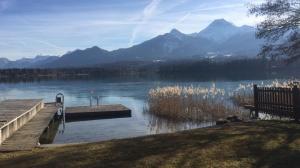 a dock on a lake with mountains in the background at Haus Daniela in Drobollach am Faaker See