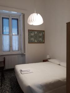 - une chambre avec un lit blanc et un lustre dans l'établissement Casa Berra, à Milan