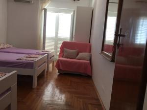 een kamer met een bed, een stoel en een raam bij GORAN'S PLACE in Hvar
