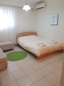 1 dormitorio con cama y alfombra verde en Studio Anna Veria, en Veria