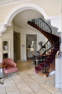 an archway in a living room with a spiral staircase at Cotswold House Hotel and Spa - "A Bespoke Hotel" in Chipping Campden