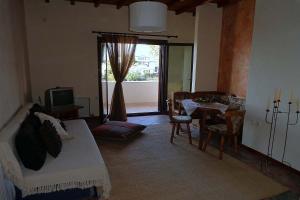 a living room with a bed and a table and a television at Klio Guesthouse in Portaria
