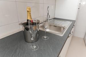 a bottle of champagne in a bucket next to a sink at Apartments Mate in Vinišće