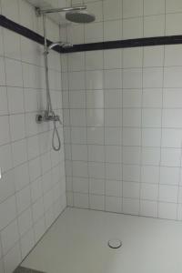 Un baño con ducha con azulejos blancos. en Appartement St. Peter a Wimberg, en Neufelden