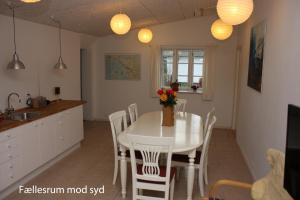 a kitchen and dining room with a white table and chairs at Holmehuset Bed & Breakfast in Kalundborg