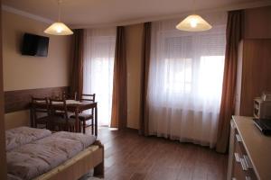 a room with a bed and a table and a kitchen at Imola és Andrea Apartmanház 2 in Hajdúszoboszló