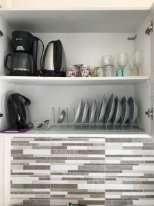 a cupboard filled with lots of utensils at Studio Zenap in Agios Georgios