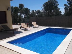 a swimming pool with two chairs and a swimming pool at Villa Hermosa in Begur