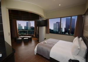 a hotel room with a large window overlooking the city at qp Hotels Lima in Lima