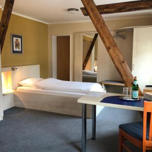 een slaapkamer met een bed en een tafel bij Hotel Select in Mönchengladbach