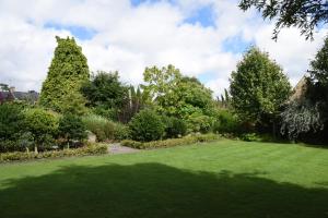 a garden with a large lawn and trees at Cotswold House Hotel and Spa - "A Bespoke Hotel" in Chipping Campden