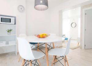 biała jadalnia z białym stołem i białymi krzesłami w obiekcie Casa do Calafate w mieście Nazaré