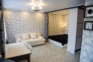 a living room with a couch and a bed at Апартаменты на Луначарского in Tyumen