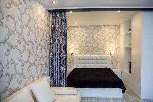 a bedroom with a white bed and a couch at Апартаменты на Луначарского in Tyumen