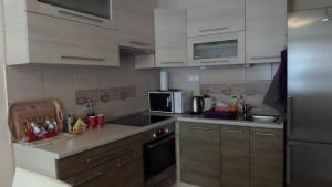 a kitchen with white cabinets and a stainless steel refrigerator at Rex Apartman in Hajdúszoboszló