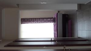 a window with a curtain in a bathroom with a sink at Rex Apartman in Hajdúszoboszló +33 photos
