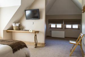 a bedroom with a bed and a tv on the wall at Casa Kalfu Hotel Boutique in Puerto Varas