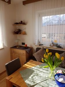 Ferienwohnung Stock في Rinn: طاولة غرفة الطعام مع إناء من الزهور عليها