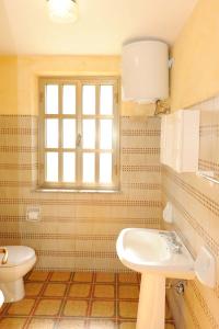 een badkamer met een wastafel en een toilet bij Villasulizzu in Budoni