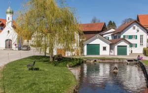 uma aldeia com uma igreja e um rio em Mara Restaurant & Hotel em Diessen am Ammersee