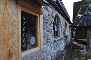 a stone building with a window with a sign on it at Willa Stella in Kościelisko