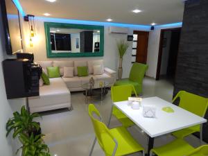 カルタヘナ・デ・インディアスにあるApartment Lux Bocagrandeのリビングルーム(ソファ、テーブル、椅子付)