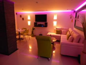 ein Wohnzimmer mit violetten Lichtern, einem Sofa und einem Tisch in der Unterkunft Apartment Lux Bocagrande in Cartagena de Indias