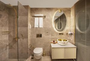 a bathroom with a shower and a toilet and a sink at Sura Design Hotel & Suites in Istanbul