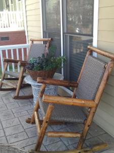 two rocking chairs and a potted plant on a porch at Sweet Magnolia in Chattanooga