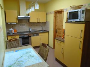 eine Küche mit gelben Schränken und einem Tisch mit einer Karte in der Unterkunft Ferienwohnung Emily in Ahlbeck