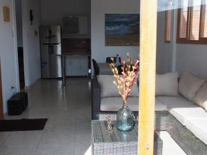 sala de estar con sofá y jarrón sobre una mesa en Los Maderos de Colan: Casa #5 +BBQ+Pool+WiFi, en Colán