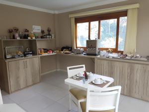 cocina con mesa, sillas y ventana en Hotel Pousada Cabana da Mata, en Gramado