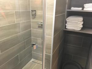 een badkamer met een douche, een toilet en handdoeken bij Le Belouga in Pornichet