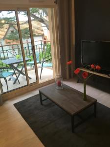 a living room with a coffee table and a television at Le Belouga in Pornichet