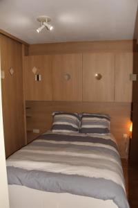 ブランケンベルヘにあるDe Brandingの木製キャビネット付きの客室の大型ベッド1台分です。