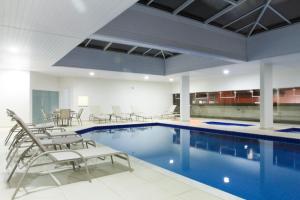 a large swimming pool with chairs and a table at The World Indaiatuba in Indaiatuba