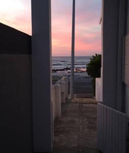 a view of the ocean from a balcony of a building at Wavey Beach Room in Melkbosstrand
