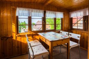 a dining room with a table and chairs and windows at Apartamenty Maki in Karpacz