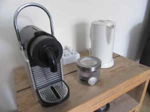 a coffee maker on a wooden table next to a blender at Bed & Breakfast Onder de Dekens in Harderwijk