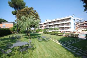 a park with tables and chairs and a building at Hotel River Palace in Terracina