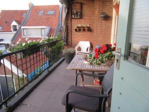 einen Balkon mit einem Tisch und Blumen darauf in der Unterkunft Bed & Breakfast Onder de Dekens in Harderwijk