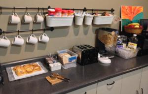una encimera de cocina con tazas de café y comida. en SunRise Inn Hotel, en Mondovi